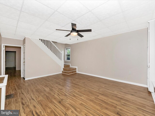 1707 Hall Ave, Baltimore, MD 21227 - unfurnished living room with wood finished floors, ceiling fan, a paneled ceiling, and stairs