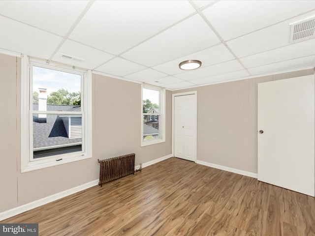 1707 Hall Ave, Baltimore, MD 21227 - empty room with radiator heating unit, a paneled ceiling, and wood finished floors
