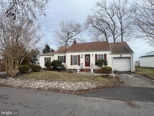5227 Al Jones Dr, Shady Side, MD 20764 - view of front facade with a garage, driveway, a chimney, a front yard, and a shingled roof