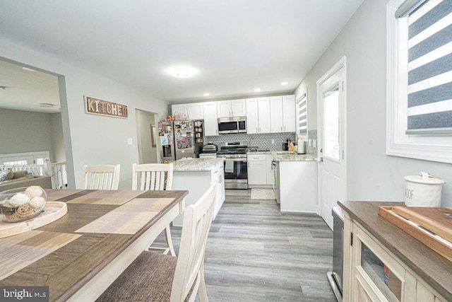 29 Holyoke Dr, Delran, NJ 08075 - kitchen with appliances with stainless steel finishes, white cabinets, light wood-style flooring, decorative backsplash, and a center island