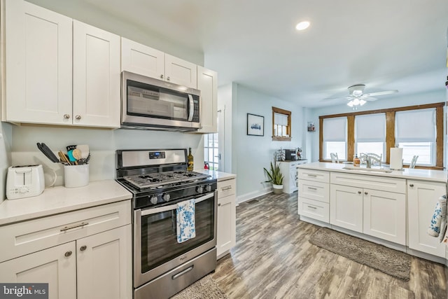122 E Pine St, Audubon, NJ 08106 - kitchen with stainless steel appliances, a sink, a ceiling fan, white cabinetry, and light countertops