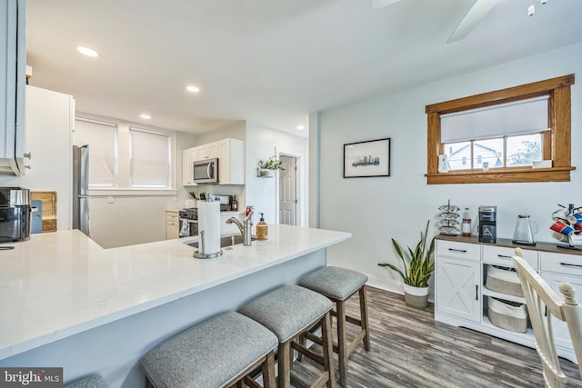 122 E Pine St, Audubon, NJ 08106 - kitchen featuring stainless steel appliances, dark wood-type flooring, a kitchen bar, baseboards, and a sink