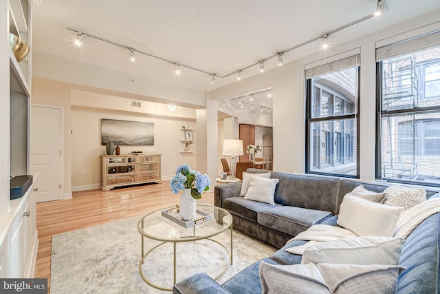 1858 California St NW Unit 20, Washington, DC 20009 - living room featuring rail lighting, light wood-style floors, and baseboards