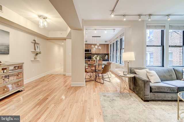 1858 California St NW Unit 20, Washington, DC 20009 - living area featuring rail lighting, light wood-style floors, and baseboards