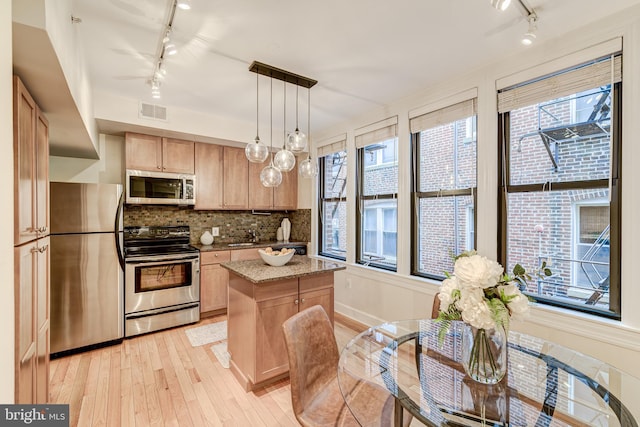 1858 California St NW Unit 20, Washington, DC 20009 - kitchen featuring rail lighting, appliances with stainless steel finishes, light wood-style flooring, and a center island