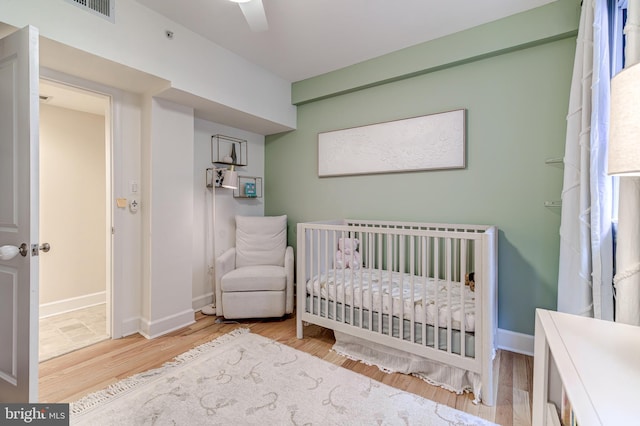1858 California St NW Unit 20, Washington, DC 20009 - bedroom featuring wood finished floors, a crib, and baseboards