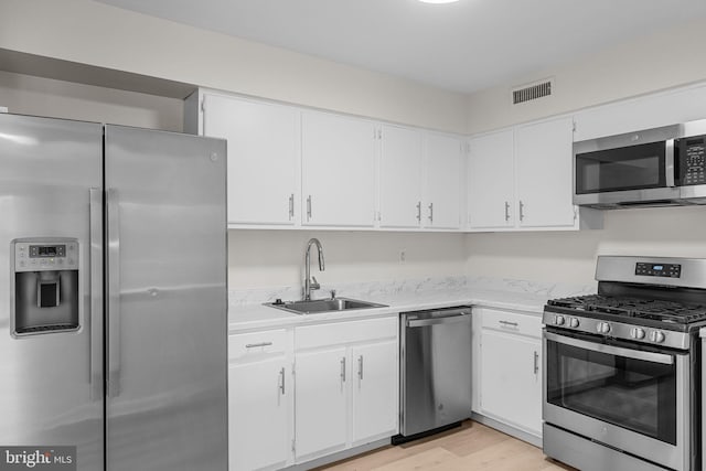 45104 Delaire Landing Rd Unit 104, Philadelphia, PA 19114 - kitchen featuring stainless steel appliances, a sink, light wood-type flooring, and white cabinetry