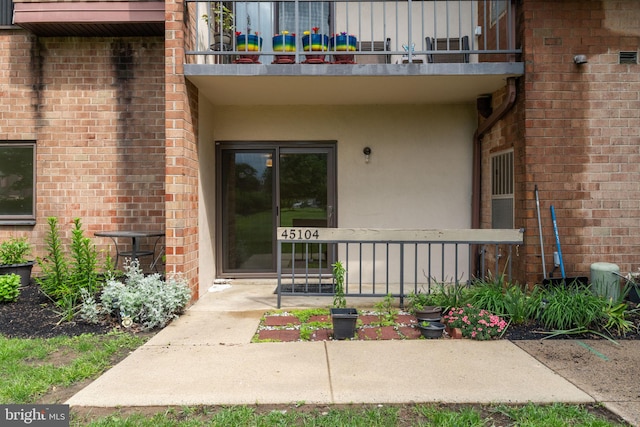 45104 Delaire Landing Rd Unit 104, Philadelphia, PA 19114 - doorway to property with a balcony, stucco siding, and brick siding