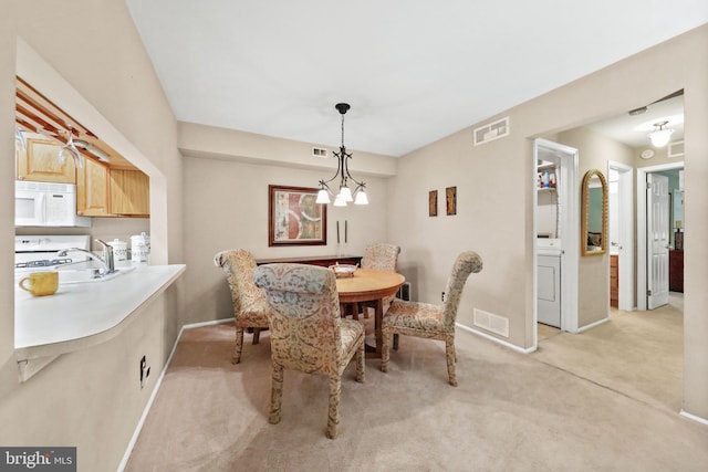 605A Ralston Dr Unit A, Mount Laurel, NJ 08054 - dining room featuring light colored carpet, washer / dryer, baseboards, and a chandelier