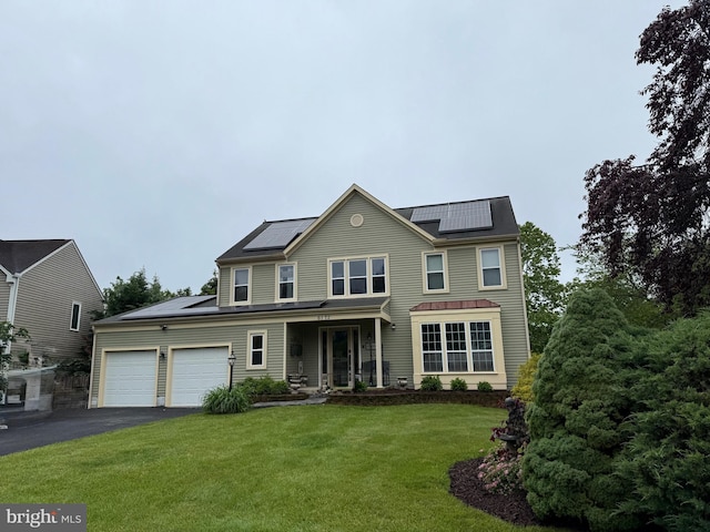 6172 Mississippi Ln, New Market, MD 21774 - back of house with solar panels, an attached garage, asphalt driveway, a lawn, and covered porch