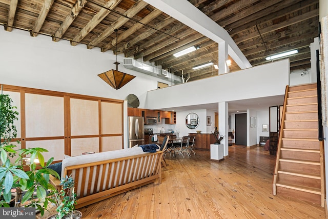 3132 E Thompson St Unit 2C, Philadelphia, PA 19134 - living area featuring a high ceiling, light wood-style flooring, and stairway