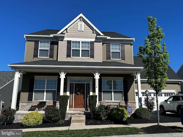 6039 Union Tunnel Dr, Harrisburg, PA 17111 - craftsman-style house with covered porch, stone siding, roof with shingles, and a garage