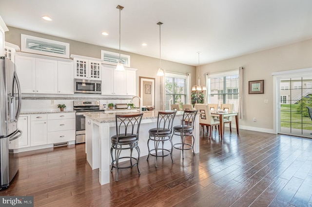 6039 Union Tunnel Dr, Harrisburg, PA 17111 - kitchen with stainless steel appliances, dark wood-style floors, tasteful backsplash, a kitchen island with sink, and white cabinets