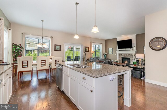 6039 Union Tunnel Dr, Harrisburg, PA 17111 - kitchen with stainless steel dishwasher, a stone fireplace, dark wood-style flooring, and a sink
