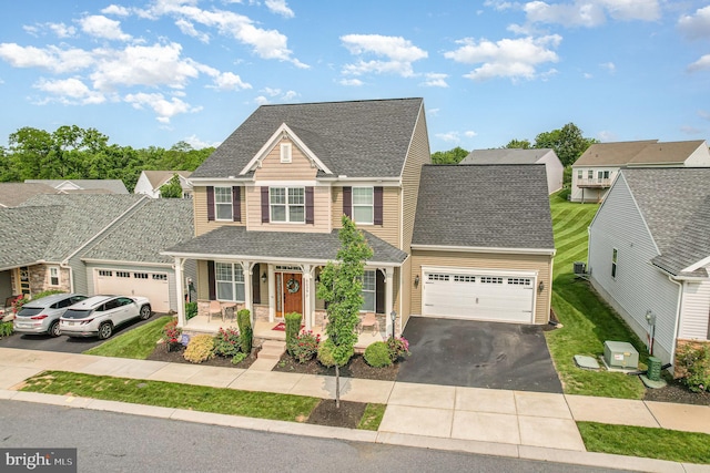 6039 Union Tunnel Dr, Harrisburg, PA 17111 - view of front of house with a porch, an attached garage, asphalt driveway, roof with shingles, and a front yard