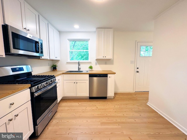 914 Townsend Blvd, Dover, DE 19901 - kitchen featuring stainless steel appliances, a sink, white cabinets, light wood-style flooring, and baseboards