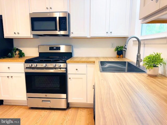 914 Townsend Blvd, Dover, DE 19901 - kitchen featuring appliances with stainless steel finishes, butcher block countertops, a sink, and white cabinetry