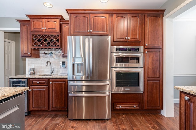 6202 Crofton Ct, Mechanicsburg, PA 17050 - kitchen featuring stainless steel appliances, light stone countertops, tasteful backsplash, a sink, and dark wood-type flooring