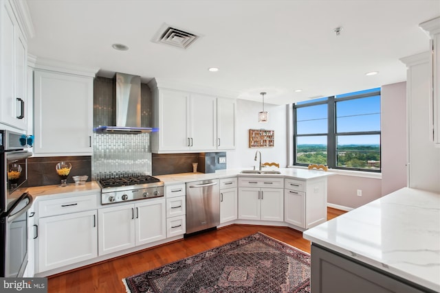 1830 Fountain Dr Unit 1107, Reston, VA 20190 - kitchen featuring stainless steel appliances, wall chimney exhaust hood, a peninsula, wood finished floors, and recessed lighting