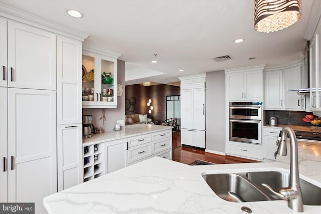 1830 Fountain Dr Unit 1107, Reston, VA 20190 - kitchen with stainless steel double oven, white cabinetry, recessed lighting, glass insert cabinets, and decorative backsplash