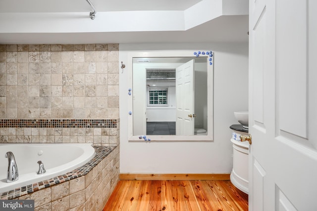 4108 Slater Ave, Baltimore, MD 21236 - bathroom featuring baseboards, wood finished floors, tiled bath, and a skylight