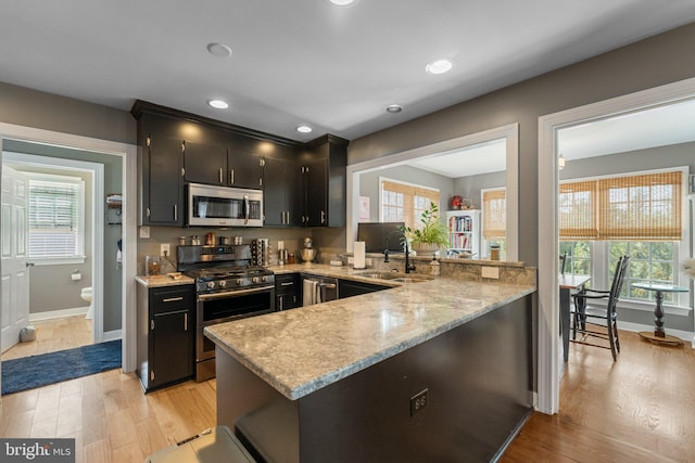 413 Benton Pt, Tappahannock, VA 22560 - kitchen with stainless steel appliances, a sink, light wood-style flooring, a peninsula, and baseboards
