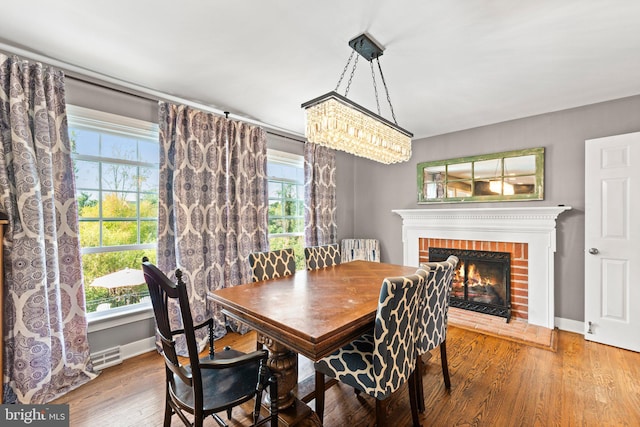 413 Benton Pt, Tappahannock, VA 22560 - dining room featuring wood finished floors, plenty of natural light, a brick fireplace, and baseboards