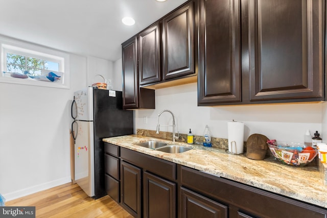 413 Benton Pt, Tappahannock, VA 22560 - kitchen with a sink, freestanding refrigerator, light wood finished floors, dark brown cabinetry, and light stone countertops