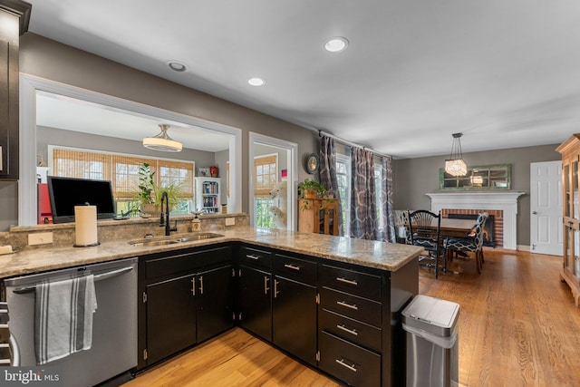 413 Benton Pt, Tappahannock, VA 22560 - kitchen featuring stainless steel dishwasher, a sink, light wood-style flooring, a fireplace, and recessed lighting