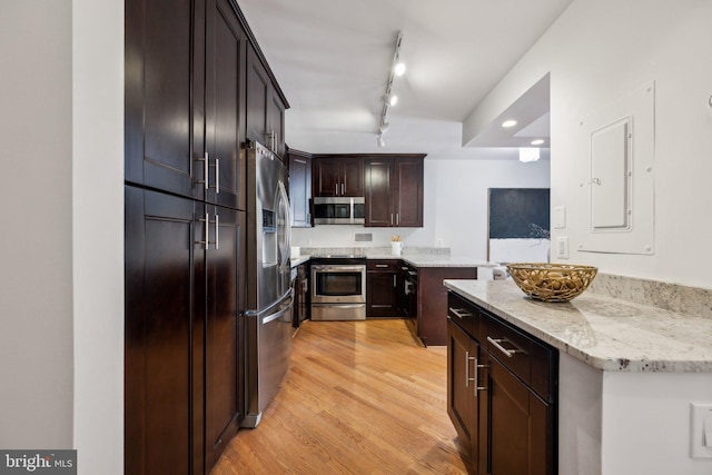 2555 Pennsylvania Ave NW Unit 918, Washington, DC 20037 - kitchen with appliances with stainless steel finishes, light wood finished floors, dark brown cabinets, light stone countertops, and rail lighting