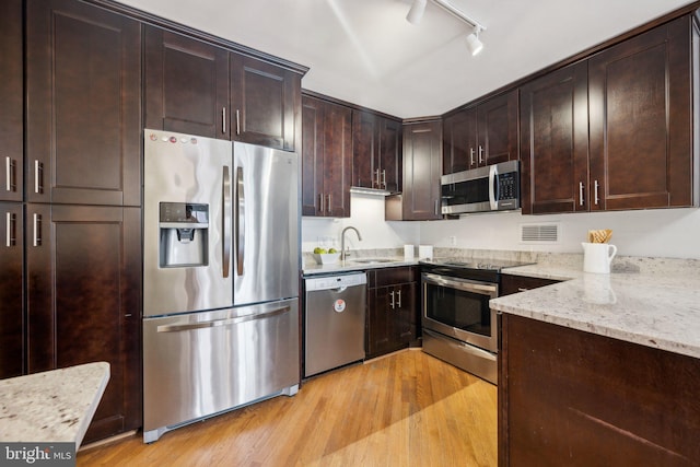 2555 Pennsylvania Ave NW Unit 918, Washington, DC 20037 - kitchen with stainless steel appliances, track lighting, light wood-style floors, light stone countertops, and dark brown cabinets