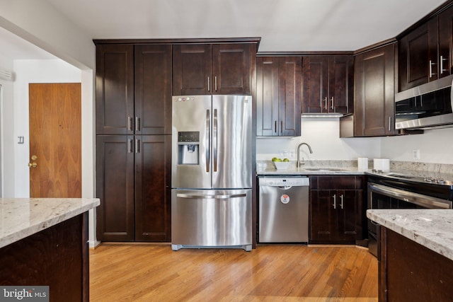 2555 Pennsylvania Ave NW Unit 918, Washington, DC 20037 - kitchen featuring appliances with stainless steel finishes, light stone counters, light wood-type flooring, and dark brown cabinets