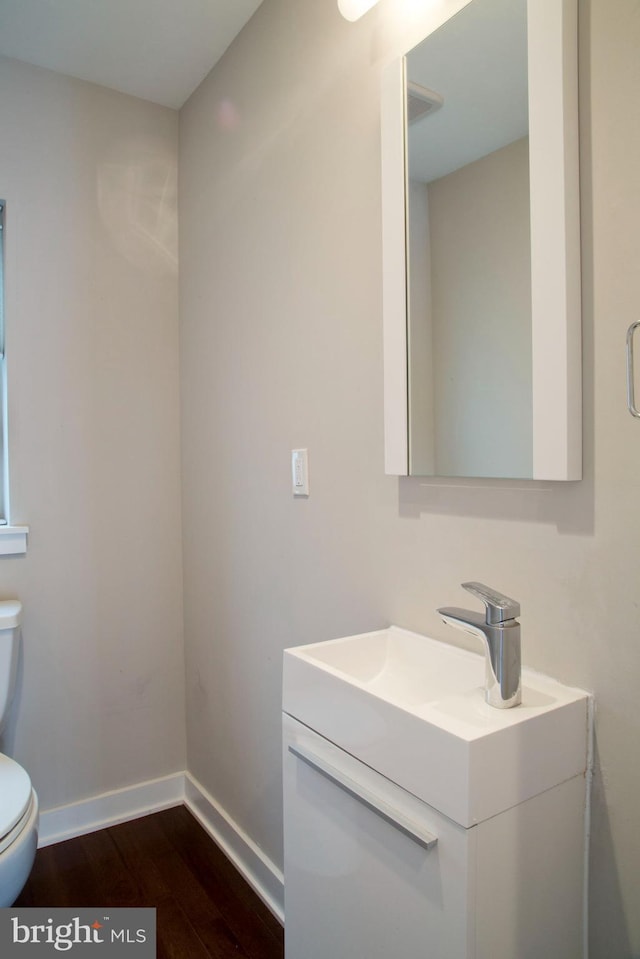 708 N 17th St, Philadelphia, PA 19130 - half bathroom with toilet, vanity, wood finished floors, and baseboards