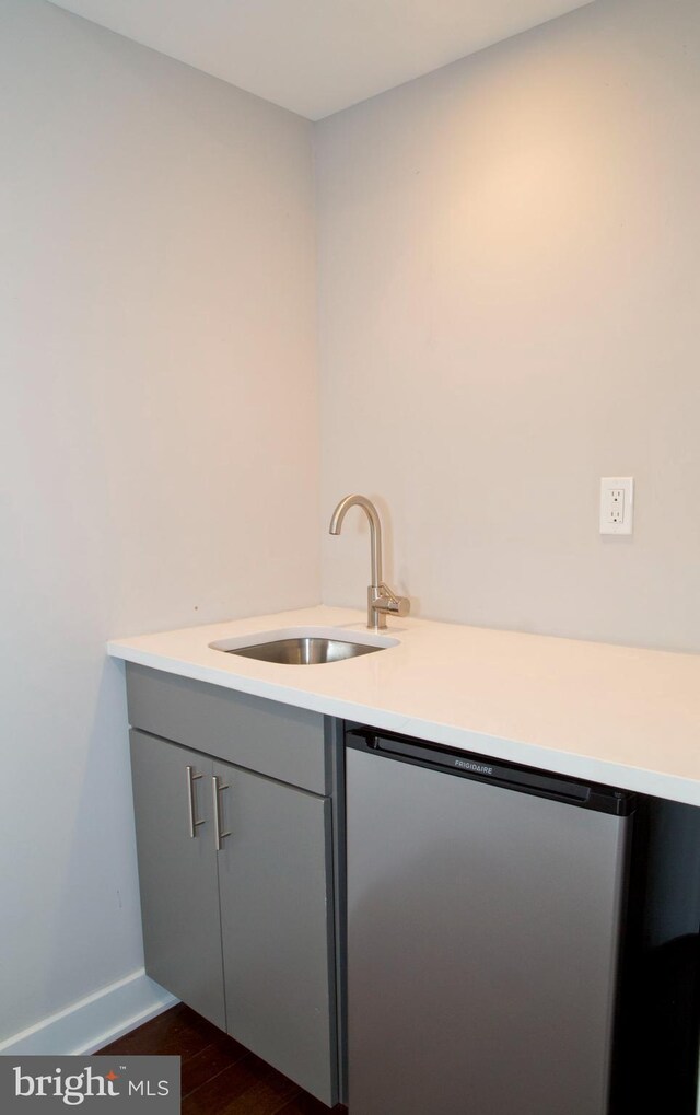 708 N 17th St, Philadelphia, PA 19130 - laundry area with a sink, dark wood-style flooring, and baseboards