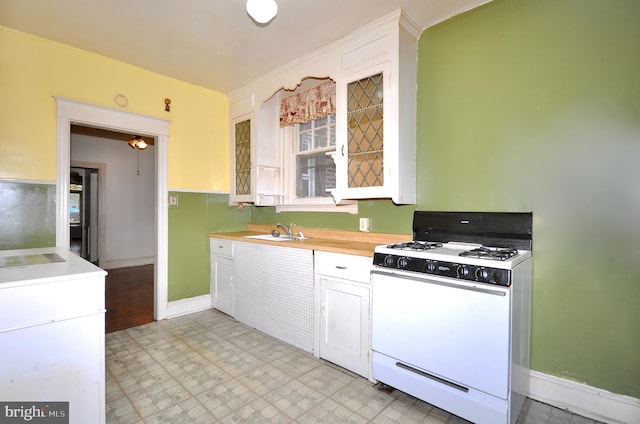 3324 Ryan Ave, Philadelphia, PA 19136 - kitchen with white gas stove, a sink, light countertops, light flooring, and white cabinetry