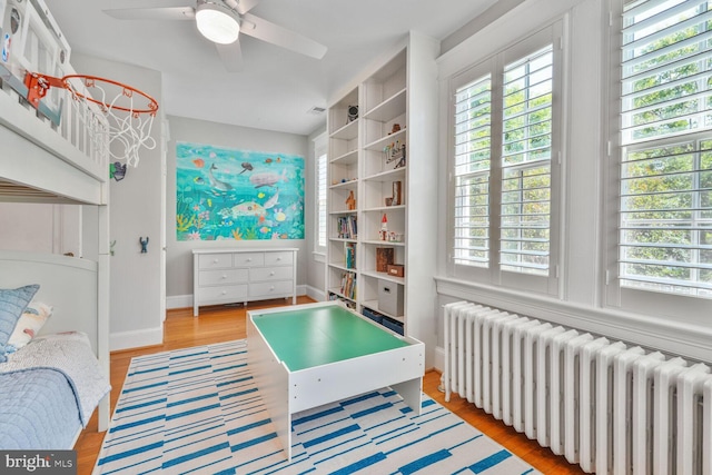 3805 Warren St NW, Washington, DC 20016 - bedroom featuring radiator heating unit, multiple windows, light wood-type flooring, and a ceiling fan