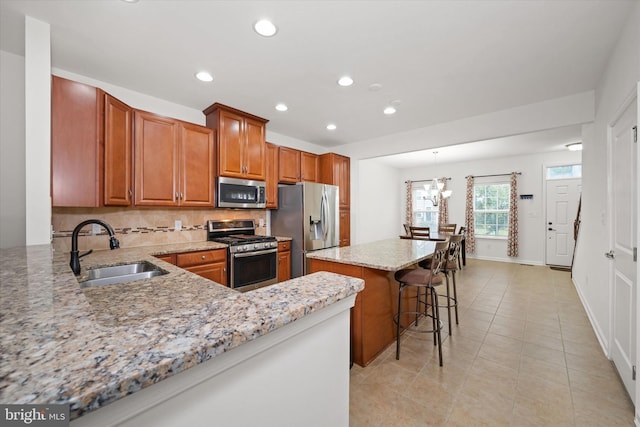 133 E General Grey Ct, Newark, DE 19702 - kitchen featuring appliances with stainless steel finishes, a sink, recessed lighting, a kitchen island, and light stone countertops