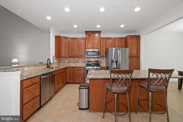 133 E General Grey Ct, Newark, DE 19702 - kitchen featuring stainless steel appliances, a sink, light stone countertops, a kitchen breakfast bar, and recessed lighting