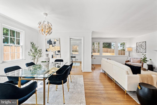 4422 Springdale St NW, Washington, DC 20016 - dining room featuring ornamental molding, plenty of natural light, a chandelier, light wood-style floors, and baseboards