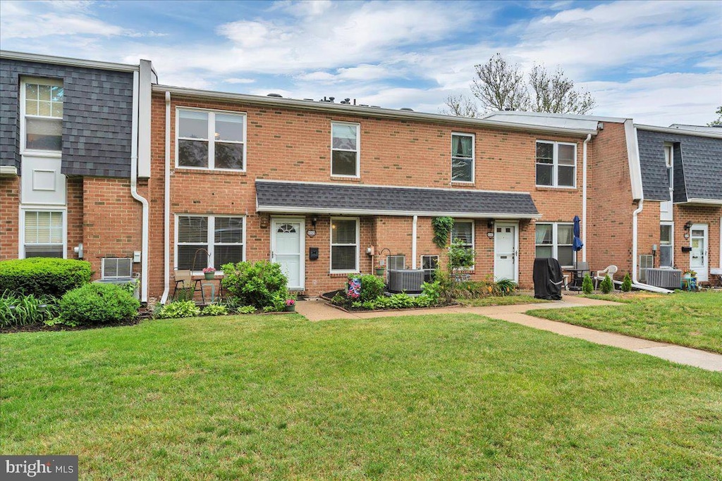 1035 Harbour Dr, Palmyra, NJ 08065 - view of property featuring a front yard, brick siding, and central air condition unit
