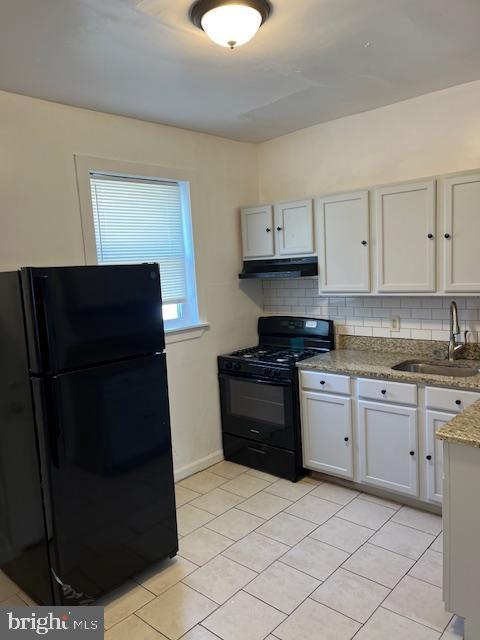 1910 Mcclellan St, Philadelphia, PA 19145 - kitchen with black appliances, a sink, under cabinet range hood, light tile patterned floors, and decorative backsplash