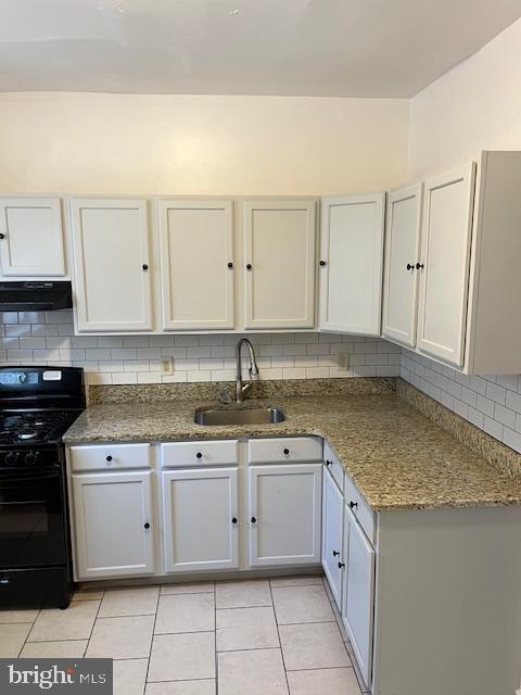 1910 Mcclellan St, Philadelphia, PA 19145 - kitchen featuring black range with gas cooktop, a sink, exhaust hood, light tile patterned flooring, and backsplash