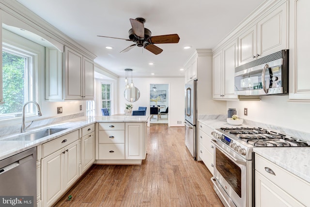 12209 Lake James Dr, Herndon, VA 20171 - kitchen featuring appliances with stainless steel finishes, ceiling fan, light wood-style flooring, a peninsula, and hanging light fixtures