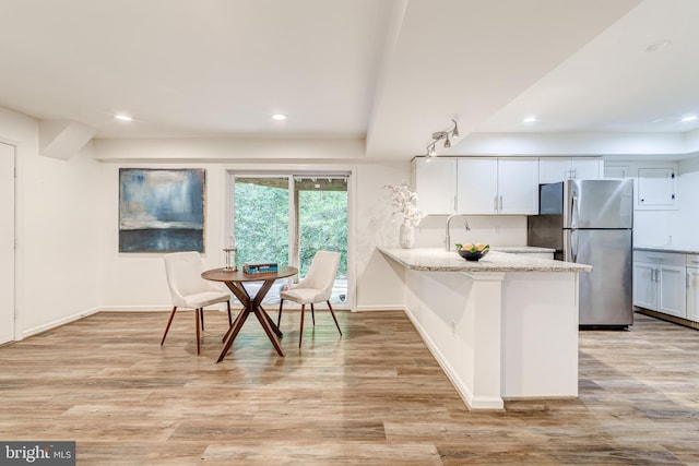 12209 Lake James Dr, Herndon, VA 20171 - kitchen featuring freestanding refrigerator, a peninsula, light wood-type flooring, light stone countertops, and recessed lighting