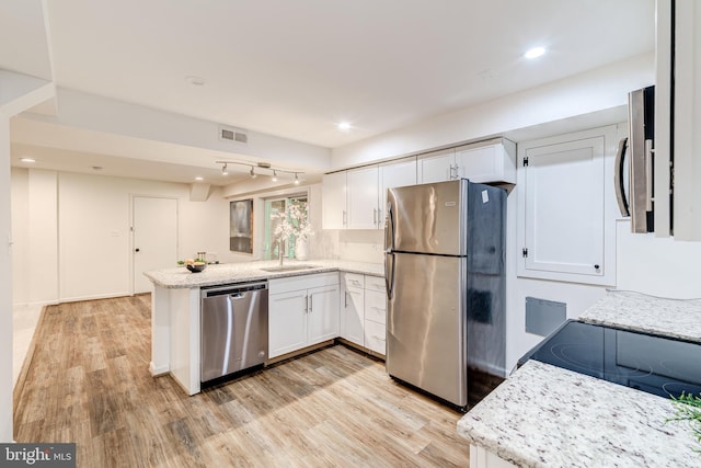 12209 Lake James Dr, Herndon, VA 20171 - kitchen featuring stainless steel appliances, a peninsula, white cabinetry, light wood-type flooring, and recessed lighting