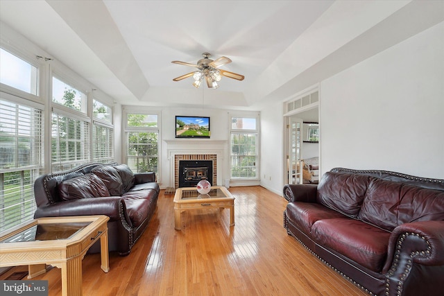 3663 Thomasson Crossing Dr, Triangle, VA 22172 - living room with a raised ceiling, a ceiling fan, light wood finished floors, and a brick fireplace