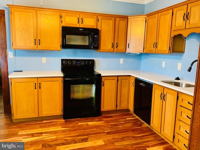 531 S 3rd St, Oakland, MD 21550 - kitchen featuring black appliances, a sink, light countertops, wood finished floors, and ornamental molding