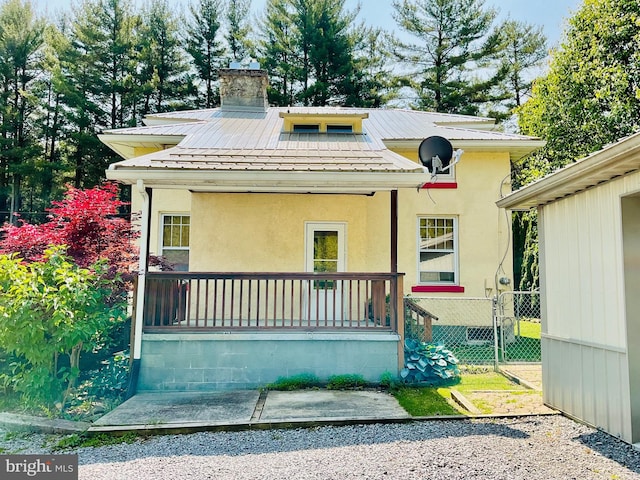 531 S 3rd St, Oakland, MD 21550 - view of front of house with metal roof, a porch, a chimney, and stucco siding