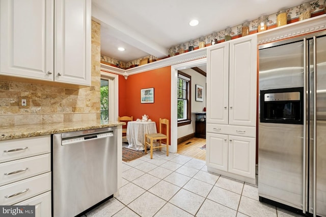 12 Sergeant St, Princeton, NJ 08540 - kitchen featuring stainless steel appliances, white cabinetry, light tile patterned floors, decorative backsplash, and baseboards