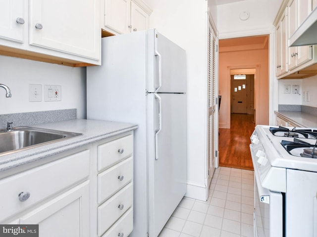 1432 C St SE, Washington, DC 20003 - kitchen with white appliances, light countertops, white cabinets, light tile patterned floors, and range hood